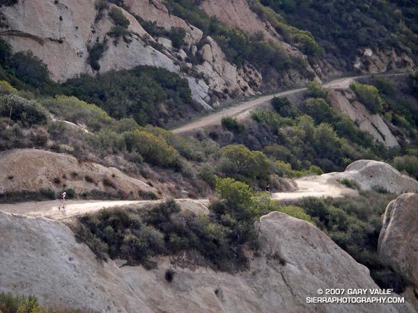 A trail runner cruises down Calabasas Peak Motorway on the way to the Stunt High Trail, Backbone Trail, Saddle Peak, and Tapia Park