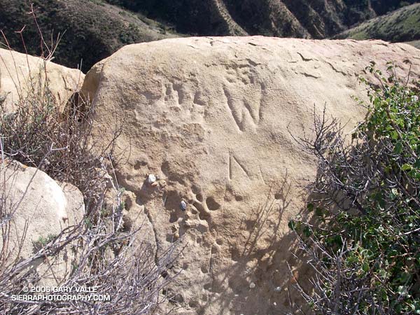 Chiseled inscriptions near summit of rock formation.