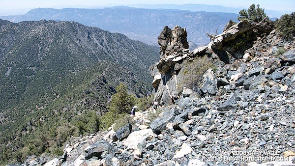 Three climbers pick their way through the rubble on the southwest ridge of Owens Peak.