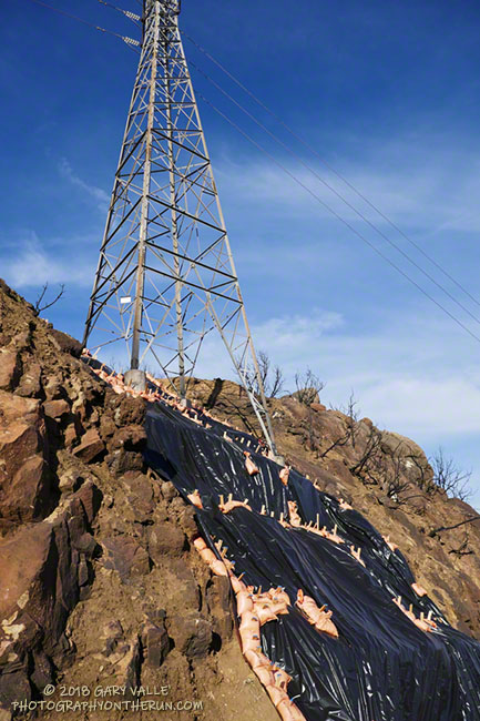 Steps to reduce erosion of the footing of a power line tower.