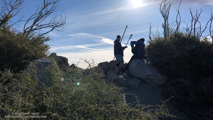 Hikers on the summit of Strawberry Peak. The peak was burned in the devastating 2009 Station Fire. The bare, burned limbs measure the growth of the vegetation since the fire.