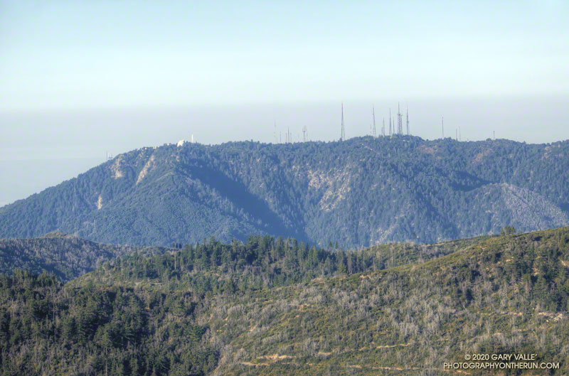Hazy view of Mt. Wilson from the Three Points-Mt. Waterman Trail. The upper section of the Rim Trail is directly below the observatory dome, and the Kenyon Devore Trail tops out at the cluster of antennas on the right.